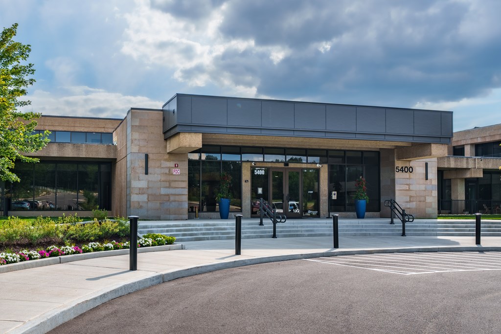 A modern building with a glass entrance and a stone facade.