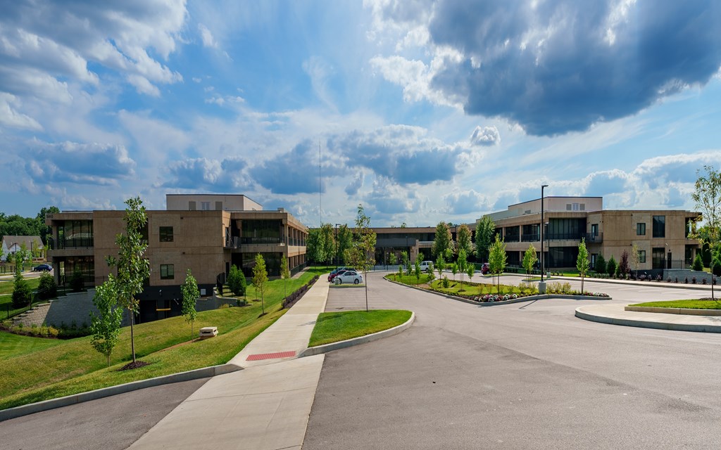 A large building complex with a parking lot in front.
