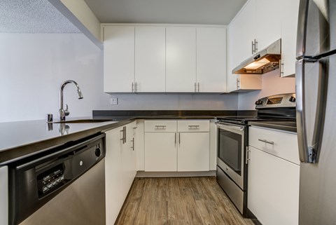 a kitchen with white cabinets and stainless steel appliances