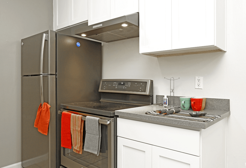 a kitchen with white cabinets and stainless steel appliances
