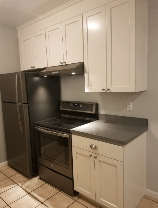 a kitchen with white cabinets and black appliances