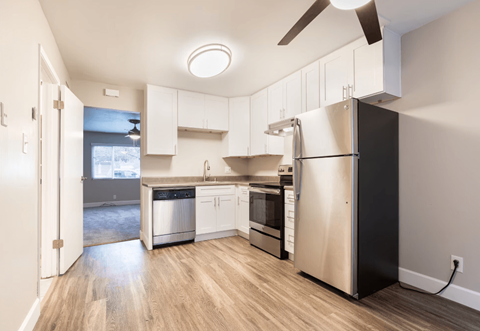 a kitchen with white cabinets and a stainless steel refrigerator