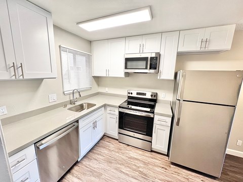 a kitchen with white cabinets and stainless steel appliances