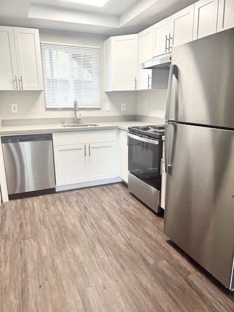 a kitchen with stainless steel appliances and white cabinets