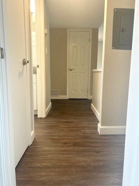 a hallway with a white door and a wood floor