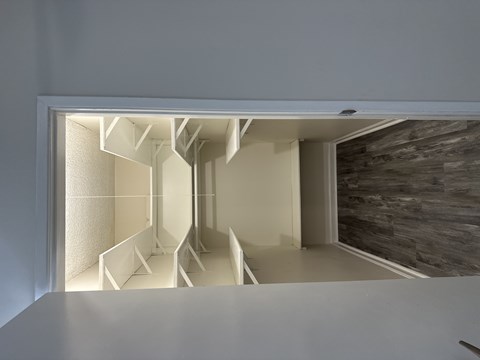 A white interior space with a stone wall and a white ceiling.