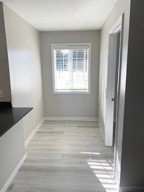 a empty room with a window and wooden floors