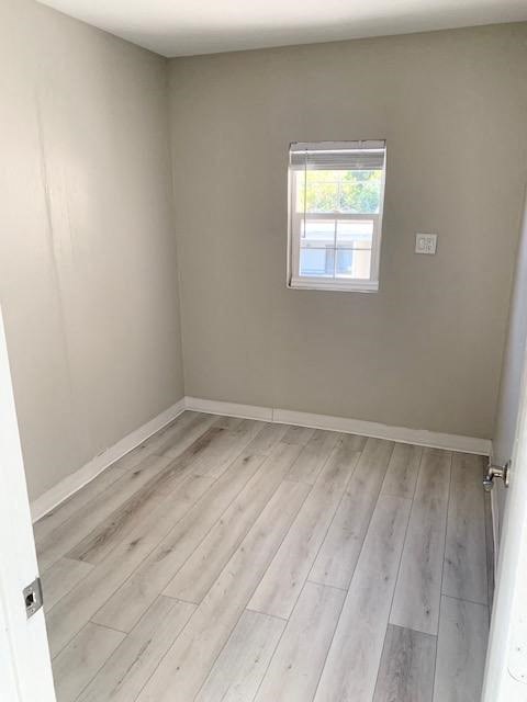 a empty room with wooden floors and a window