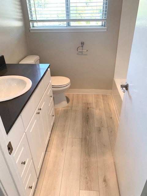 a bathroom with a toilet and a sink and a window