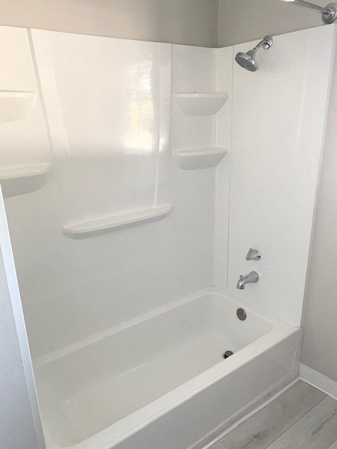 a white bathroom with a shower and a tub