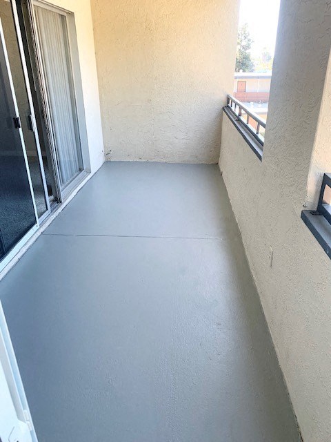 a balcony with a concrete floor and a window