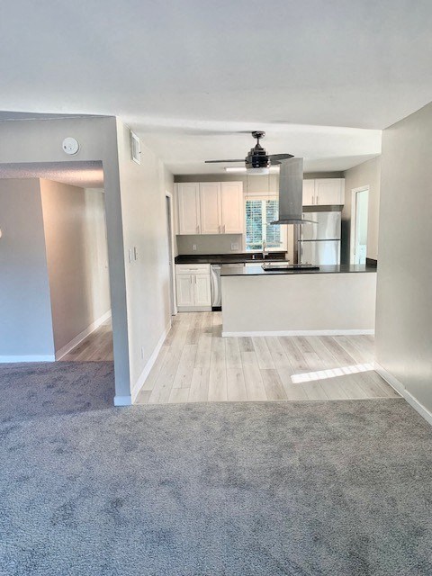 an empty living room with a kitchen in it