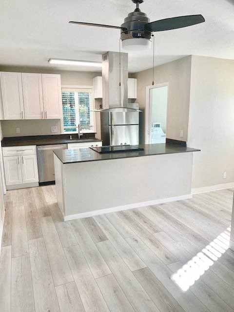 a kitchen with a island and a ceiling fan