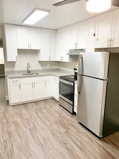 a white kitchen with a refrigerator and a stove