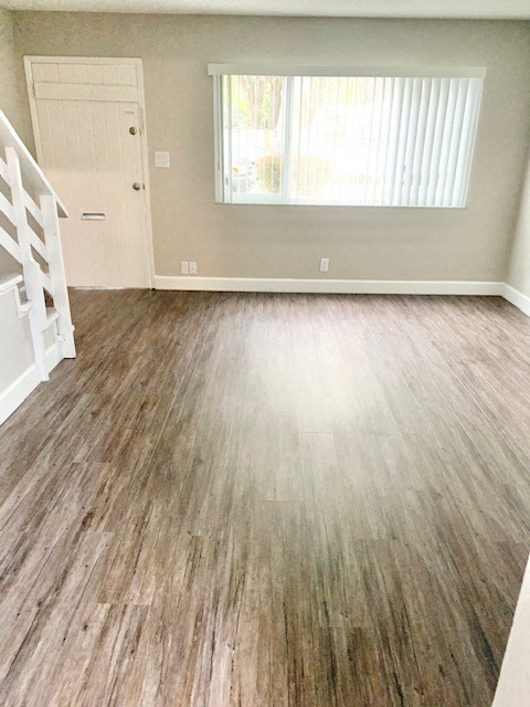 an empty living room with a wooden floor