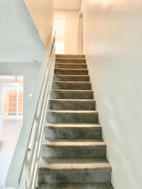 a staircase with a railing and carpeted stairs