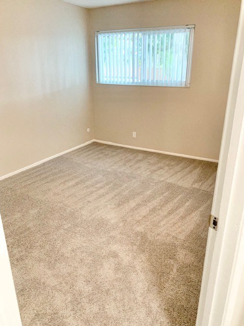 an empty room with carpet and a window