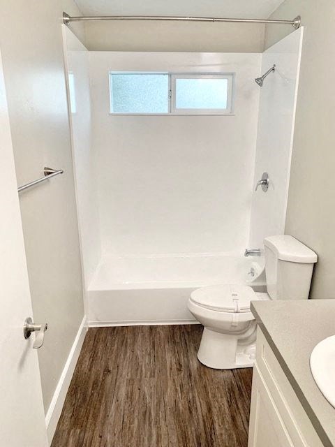 a white bathroom with a toilet and a tub and a sink