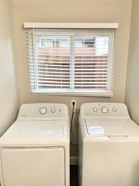 two washers and a window in a small laundry room