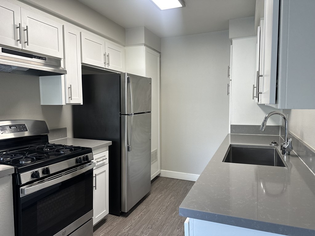 A kitchen with a black stove top oven and a black refrigerator.