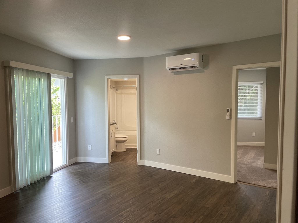 an empty living room with a heater on the wall