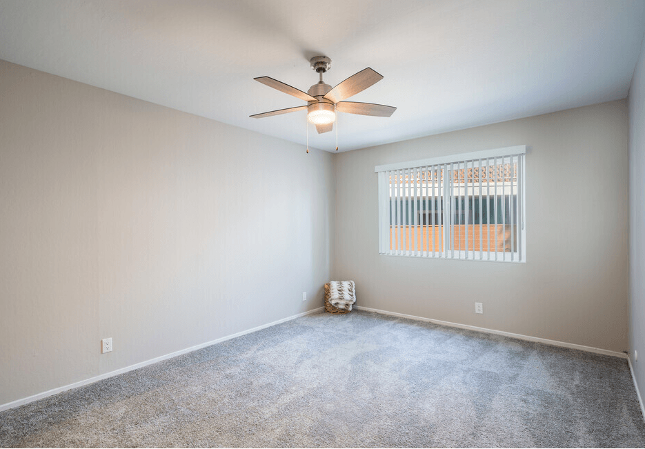 a bedroom with a ceiling fan and a window