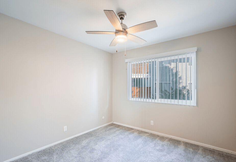 a bedroom with a ceiling fan and a window