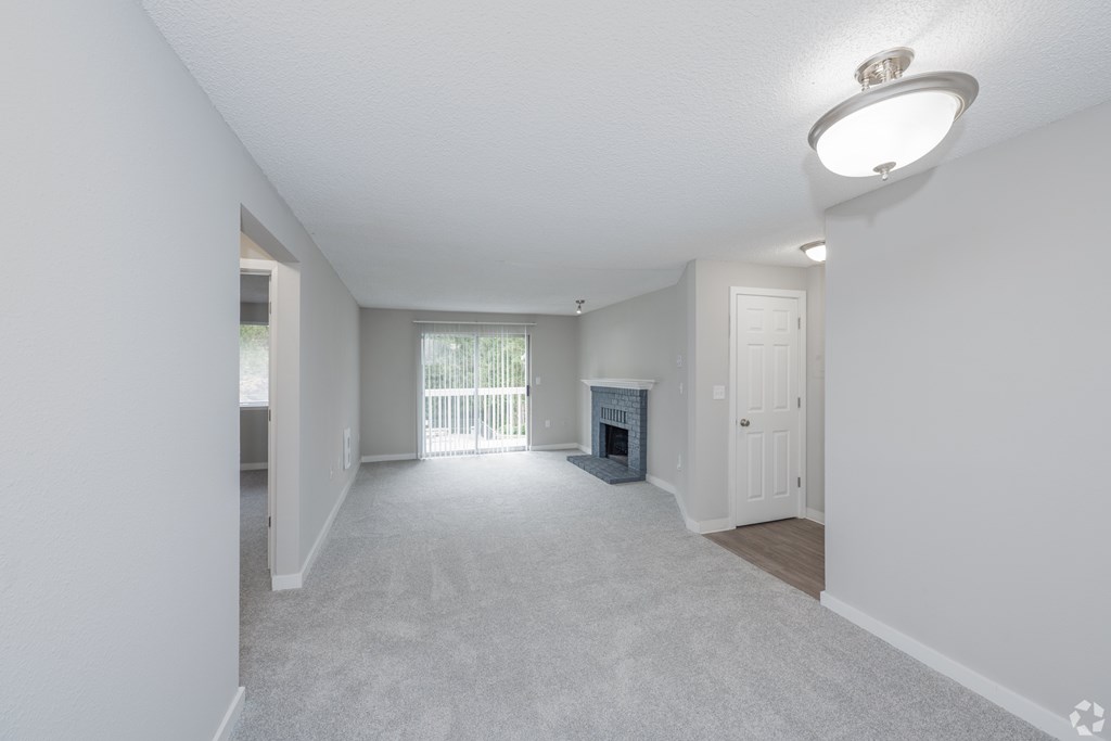 A spacious living room with a fireplace and sliding glass doors.