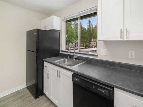 a kitchen with a sink and refrigerator and a window