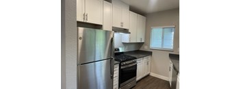 a kitchen with white cabinets and stainless steel appliances