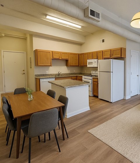 A kitchen with a table and chairs.