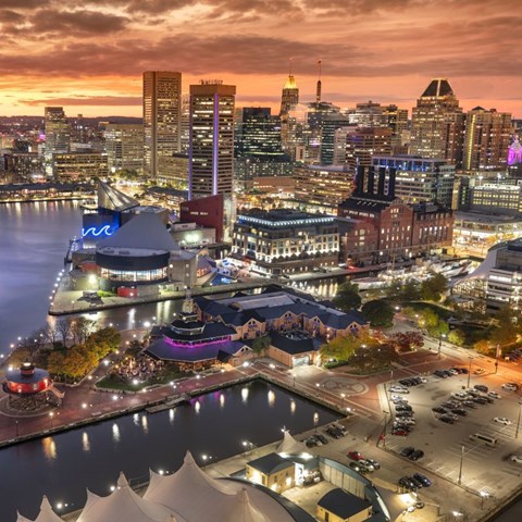 A cityscape at dusk with a large building in the foreground.