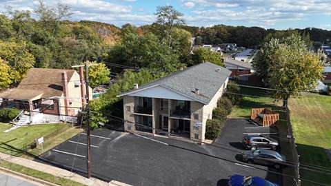 A parking lot is in front of a building with a covered entrance.