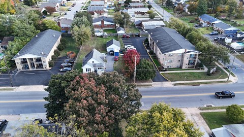 A street view of a residential area with houses and cars.