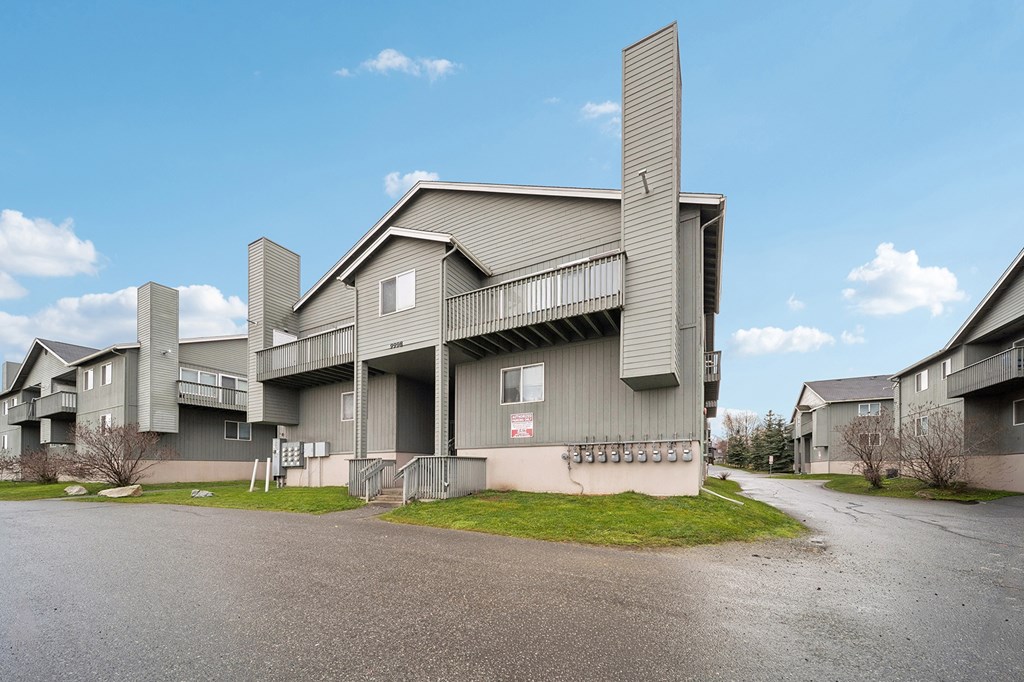 A large grey building with a balcony and a smaller building to its left.