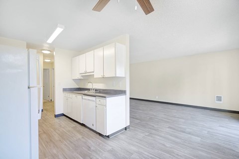 A kitchen with white cabinets and a grey countertop.
