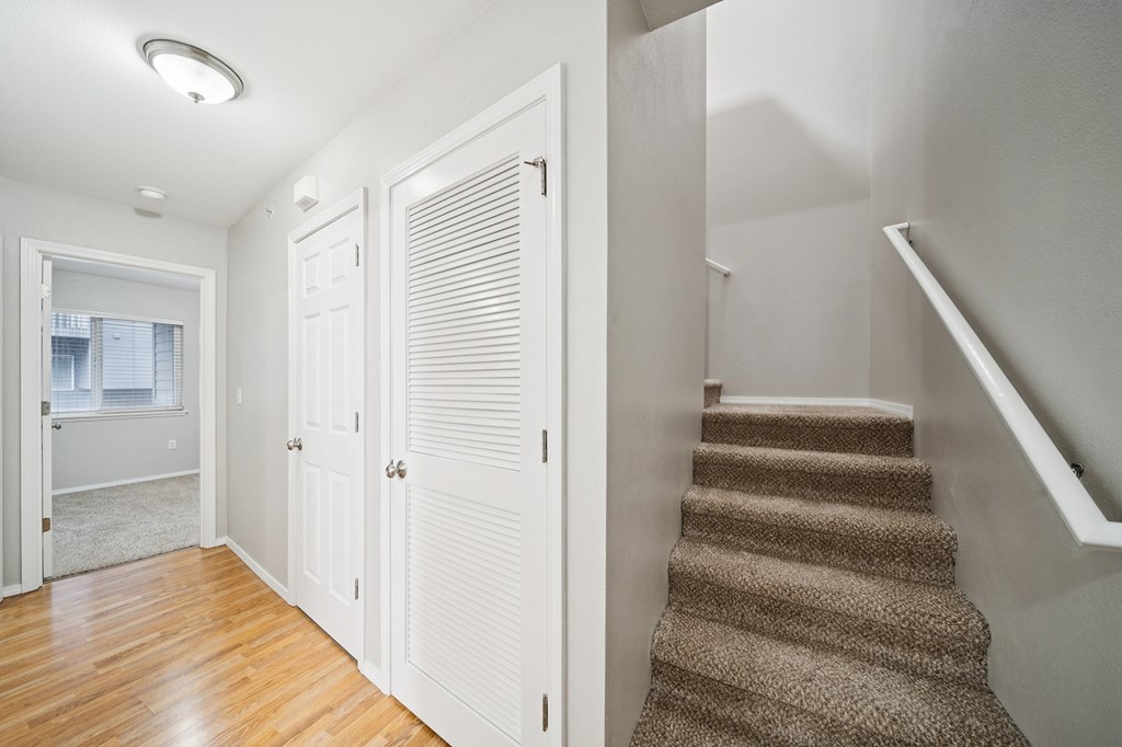 A hallway with a staircase and a window.