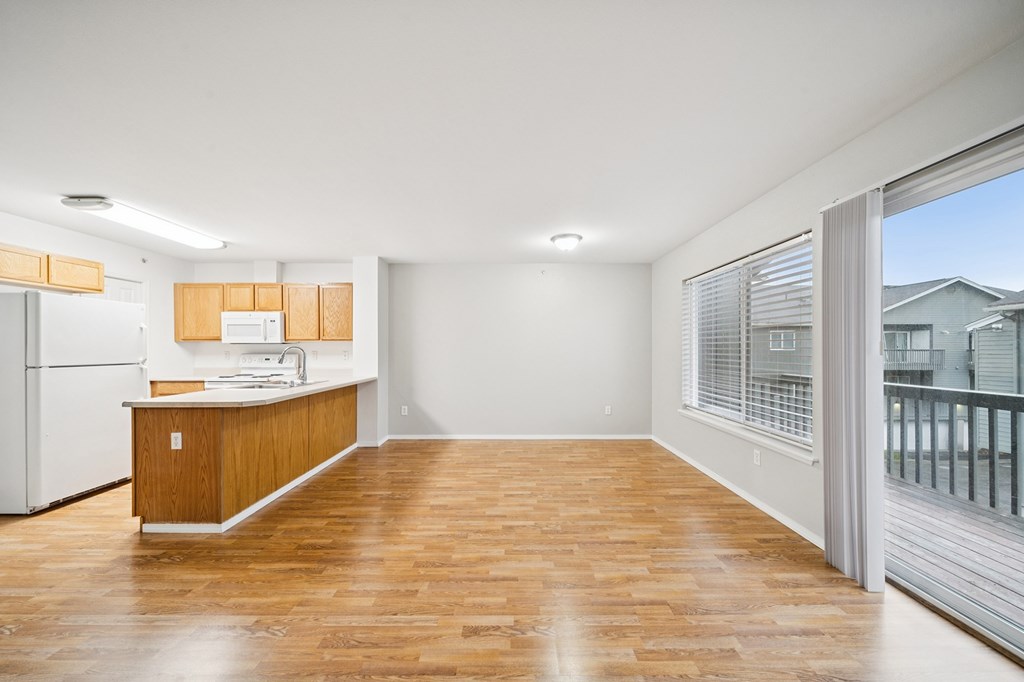 A kitchen with wooden floors and white appliances.