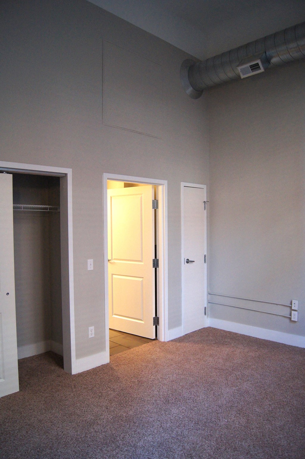 an empty room with a door open to a closet