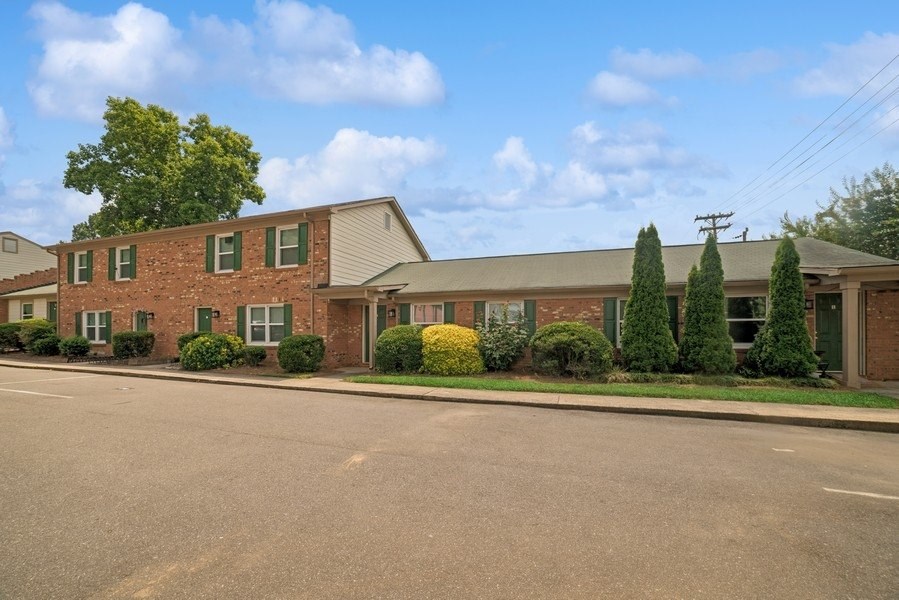 A building with a green lawn in front.
