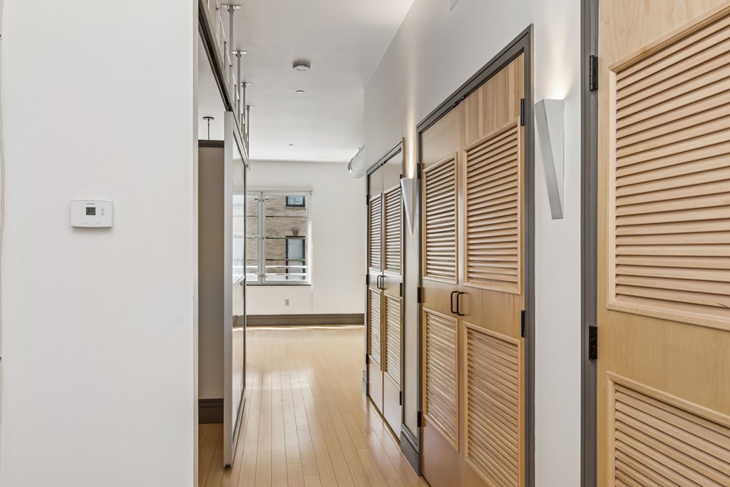 A hallway with wooden doors and a white wall.