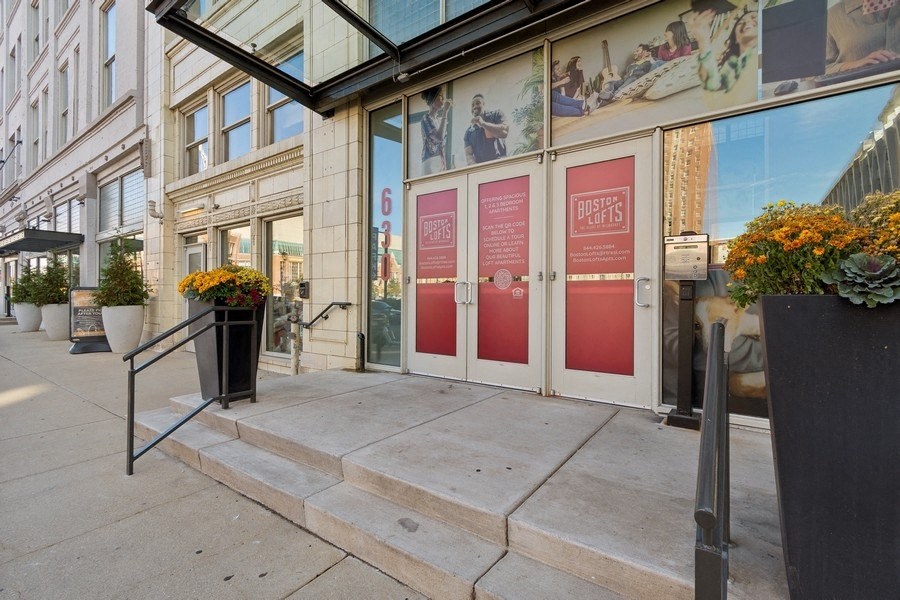 the entrance to a building with three red doors and two steps