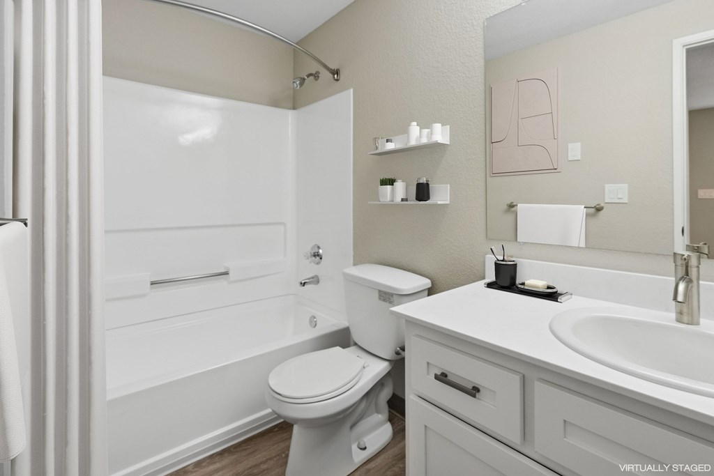 A white toilet sits next to a white sink in a bathroom.