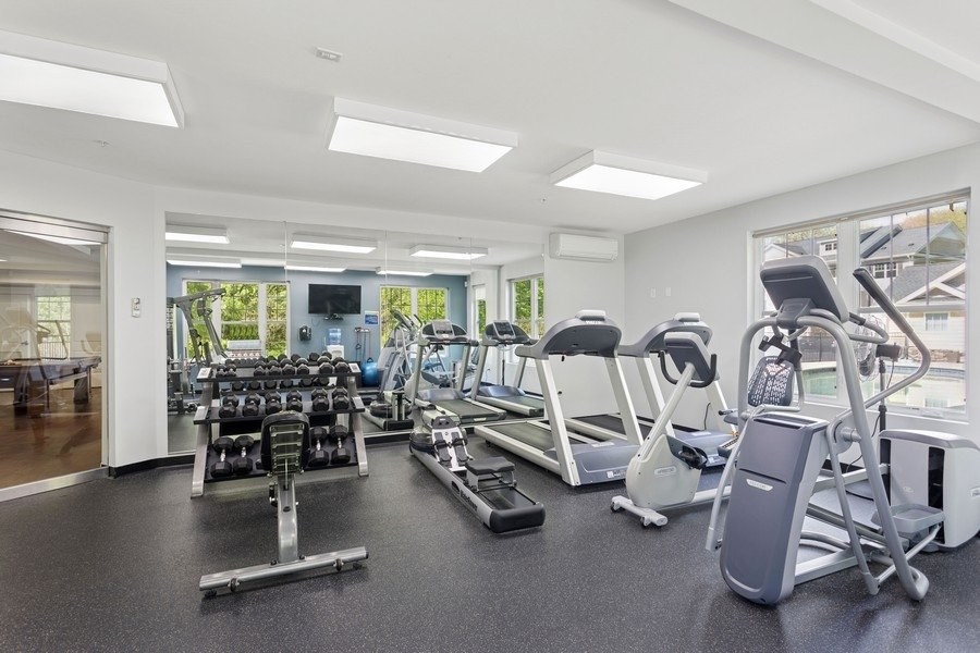 A gym with treadmills, weights, and exercise machines.