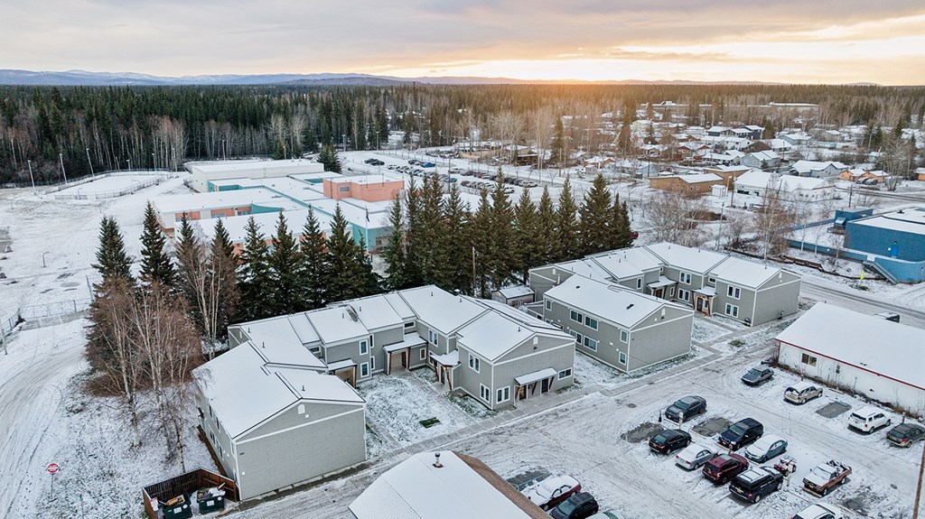 A snowy landscape with a building and cars.