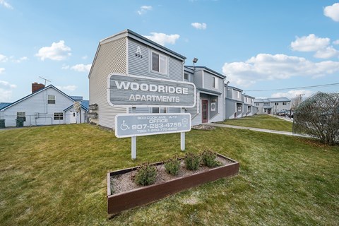 A sign for Woodridge Apartments stands in front of the building.