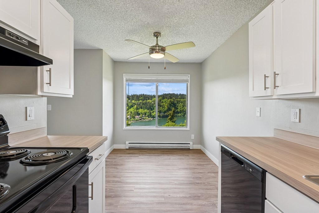 A kitchen with a black stove top oven and white cabinets.