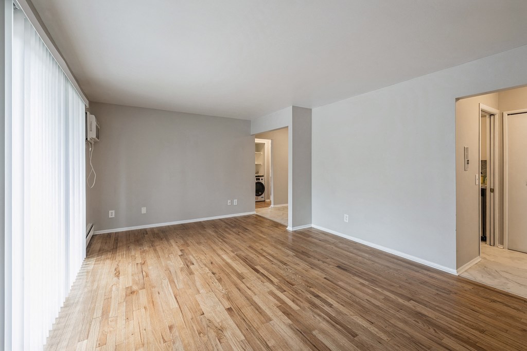 an empty living room with wood floors and grey walls