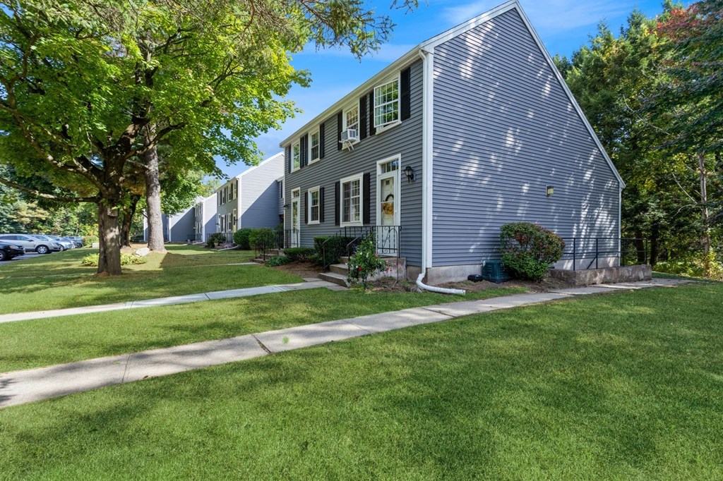 Exterior view of our apartments with a sidewalk and landscaping in front at Arbor Commons