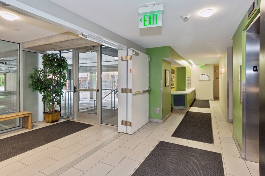 A hallway with a green exit sign at the top.